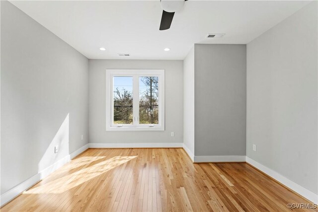 empty room featuring light wood-style floors, recessed lighting, visible vents, and baseboards