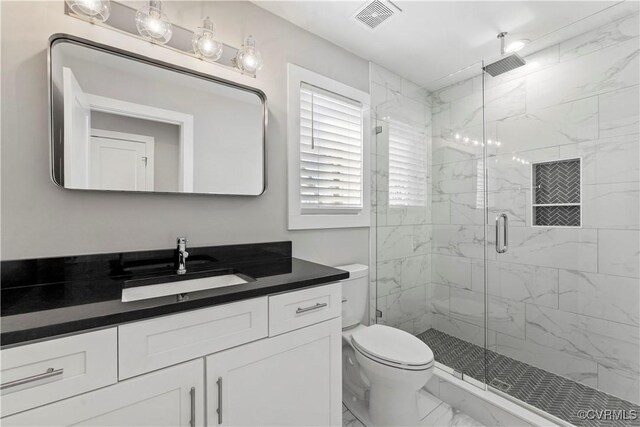 bathroom featuring marble finish floor, a marble finish shower, visible vents, toilet, and vanity