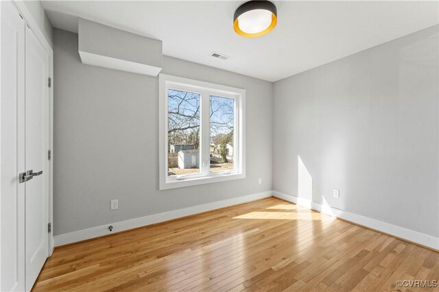 unfurnished bedroom with light wood finished floors, visible vents, and baseboards