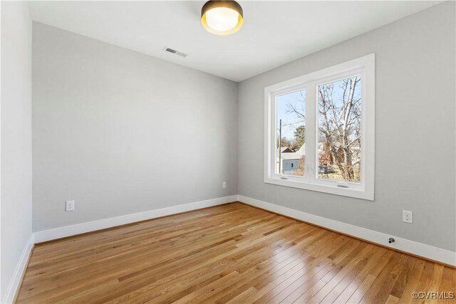 unfurnished room with light wood-type flooring, baseboards, and visible vents