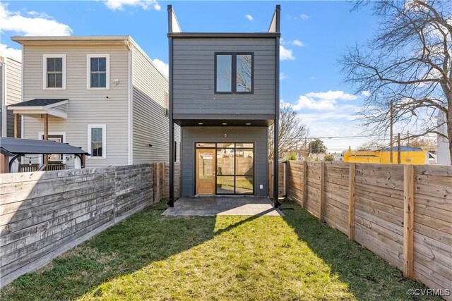 rear view of property featuring a patio area, a fenced backyard, and a yard