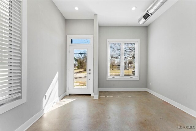 doorway with concrete flooring, recessed lighting, and baseboards