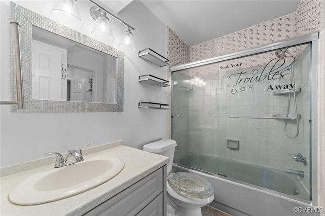 full bath featuring toilet, combined bath / shower with glass door, and vanity