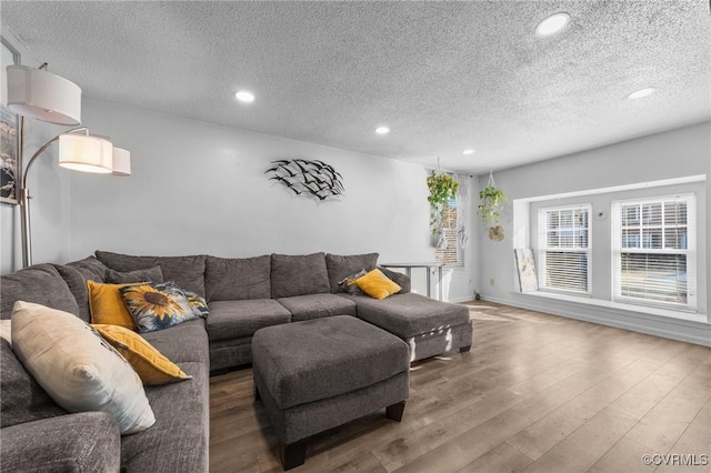 living area with recessed lighting, a textured ceiling, and wood finished floors