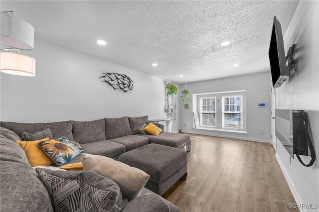 living room with wood-type flooring, baseboards, a textured ceiling, and recessed lighting