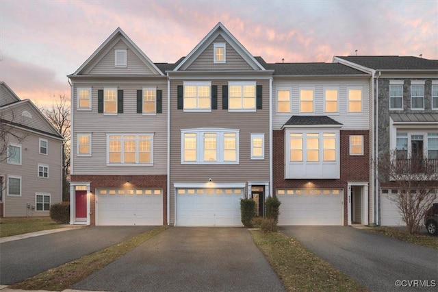 townhome / multi-family property featuring driveway and an attached garage