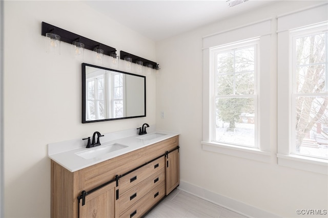 full bathroom featuring double vanity, a sink, and a wealth of natural light