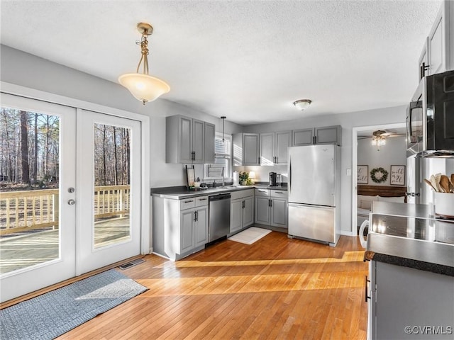 kitchen featuring appliances with stainless steel finishes, dark countertops, and gray cabinets