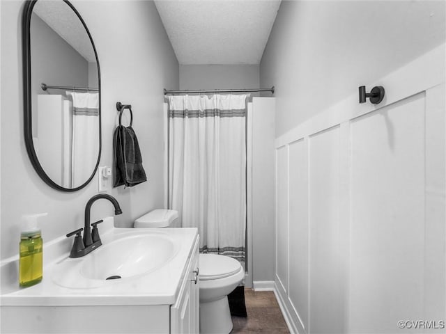 full bath featuring a textured ceiling, toilet, wood finished floors, vanity, and a shower with curtain