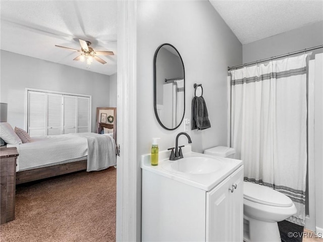 ensuite bathroom featuring a ceiling fan, toilet, ensuite bath, a textured ceiling, and vanity