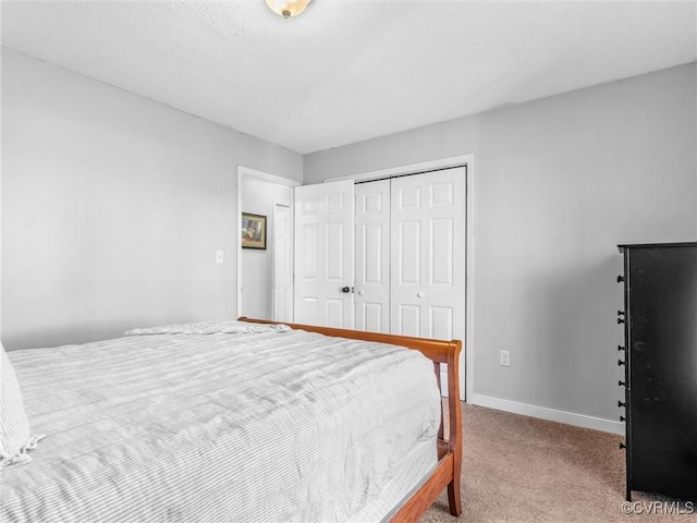 bedroom featuring baseboards, a closet, and light colored carpet