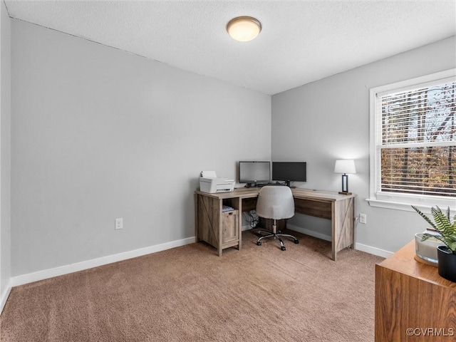 office space with baseboards, a textured ceiling, and light colored carpet