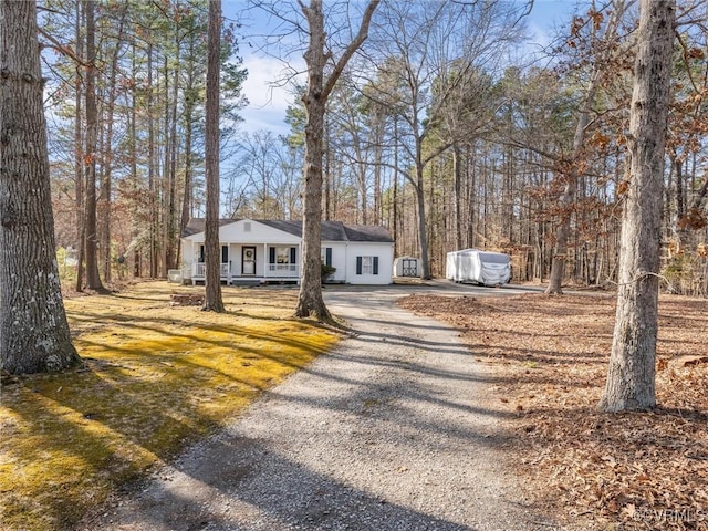 view of front of home featuring gravel driveway and covered porch