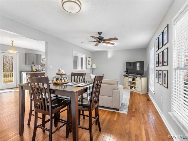 dining room featuring baseboards, a ceiling fan, and light wood-style floors