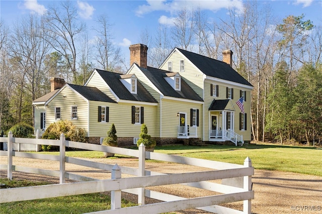 view of front of property featuring a fenced front yard, a chimney, and a front lawn