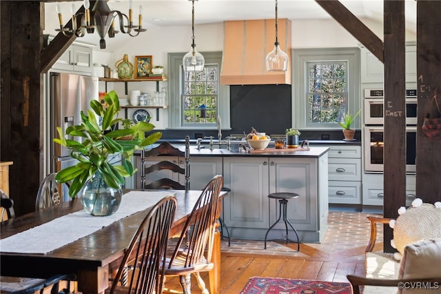 kitchen with dark countertops, appliances with stainless steel finishes, gray cabinetry, pendant lighting, and a sink