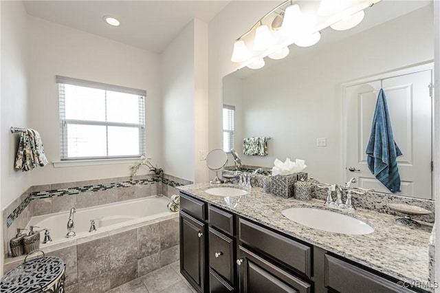 full bathroom with a garden tub, double vanity, a sink, and tile patterned floors