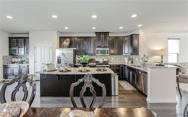 kitchen featuring appliances with stainless steel finishes, a breakfast bar, and light stone countertops