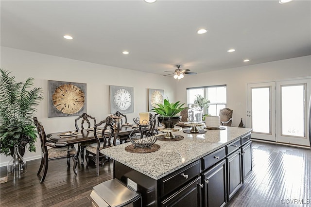 kitchen with light stone counters, dark wood finished floors, dark cabinetry, and recessed lighting