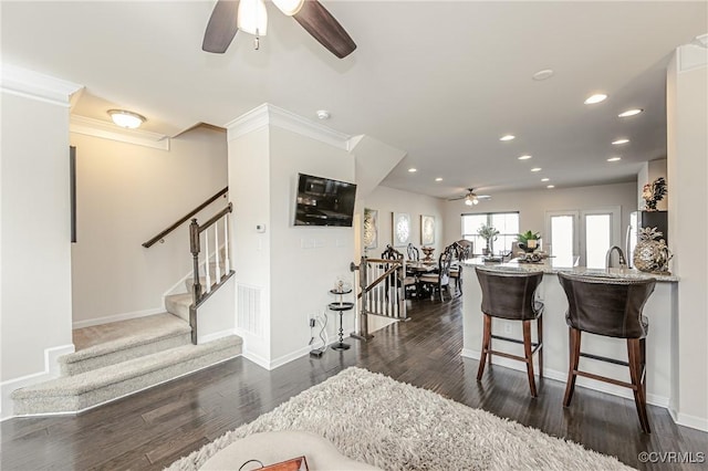 interior space with stone counters, freestanding refrigerator, dark wood finished floors, and a kitchen bar