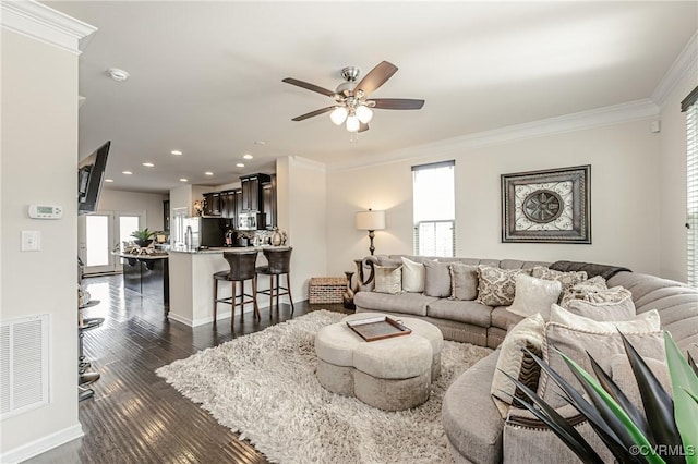 living room featuring ornamental molding, a healthy amount of sunlight, and visible vents