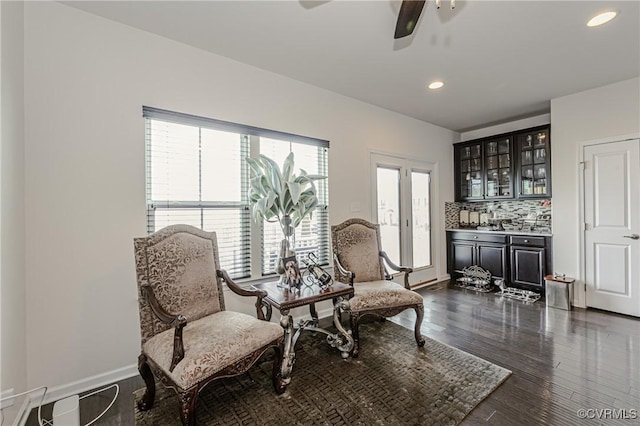 sitting room featuring ceiling fan, recessed lighting, indoor bar, baseboards, and dark wood finished floors