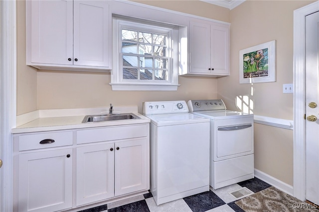 laundry room with a sink, visible vents, baseboards, independent washer and dryer, and cabinet space