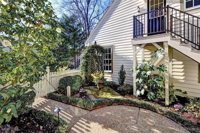 view of home's exterior with a balcony, fence, and a patio