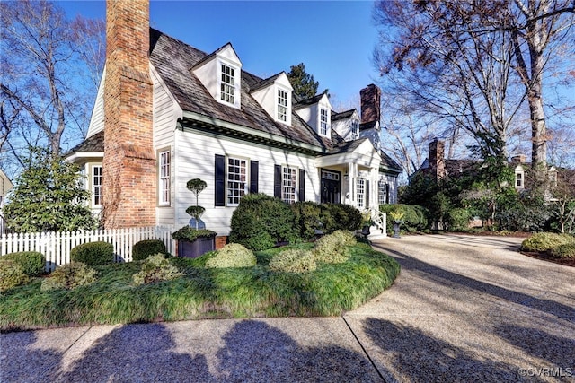 view of side of property featuring fence and a chimney