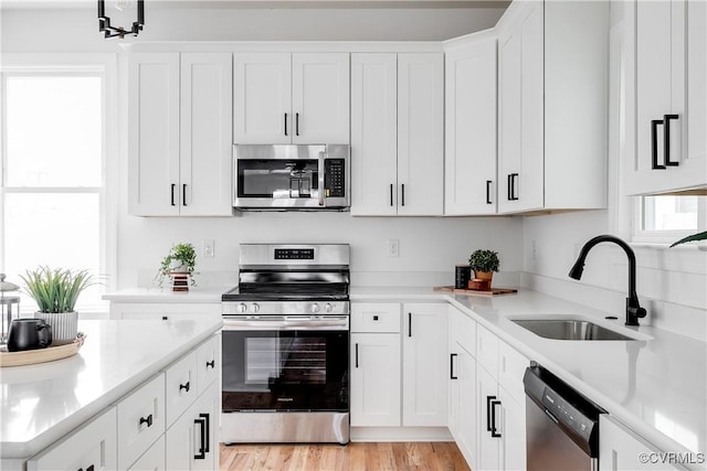 kitchen featuring a sink, stainless steel appliances, and light countertops