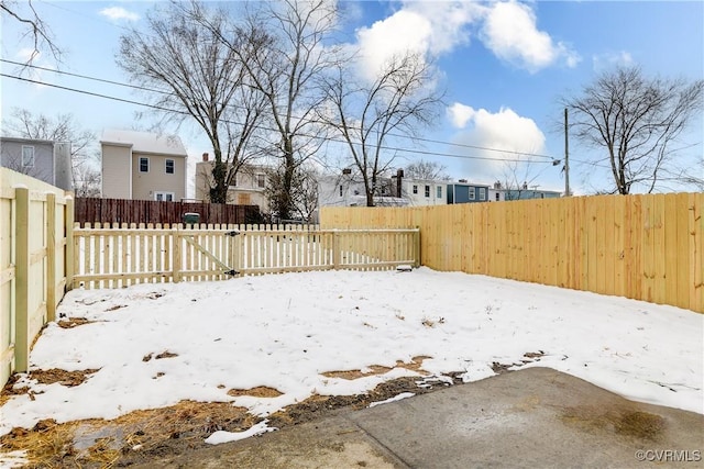 yard layered in snow featuring a fenced backyard