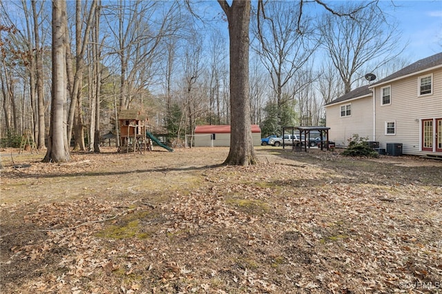 view of yard with a playground and central air condition unit