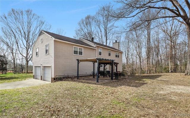 view of front facade with driveway, a chimney, an attached garage, a front lawn, and central AC