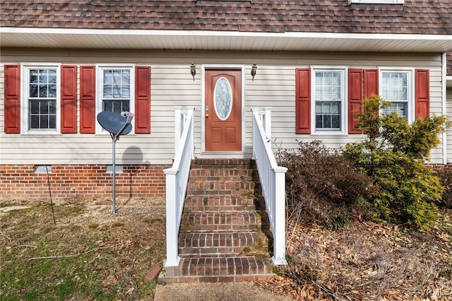 entrance to property featuring roof with shingles