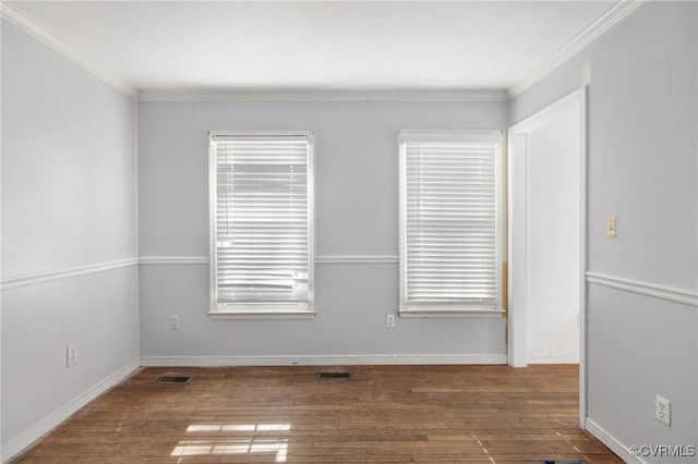 spare room featuring dark wood-style floors, baseboards, visible vents, and ornamental molding