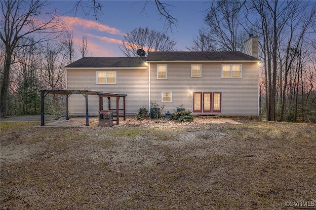 back of house at dusk with a patio, a chimney, and a pergola