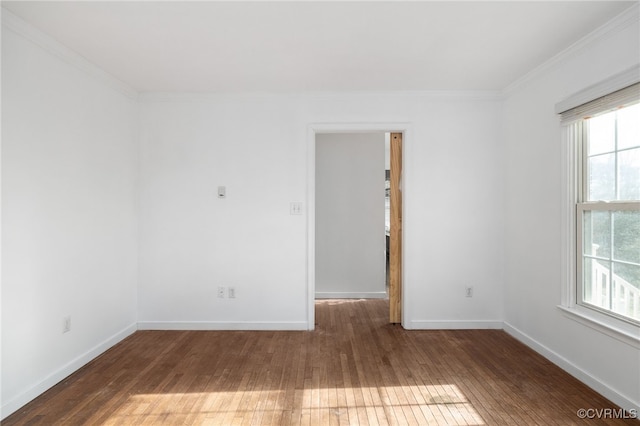 empty room with ornamental molding, dark wood finished floors, and baseboards