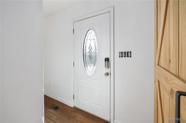 foyer entrance featuring dark wood-type flooring, visible vents, and baseboards