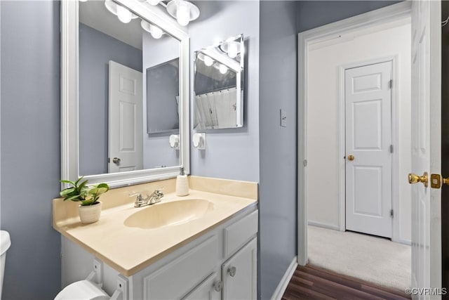 full bath featuring toilet, baseboards, and vanity