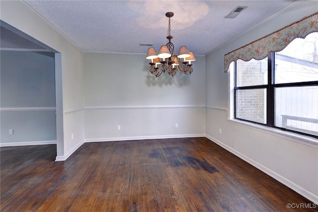 spare room with baseboards, visible vents, ornamental molding, dark wood-style flooring, and a notable chandelier