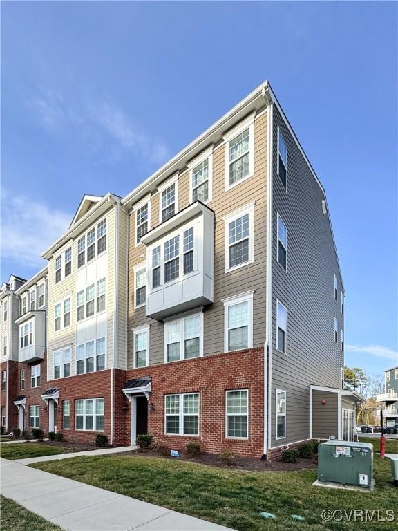 view of front of home featuring a front yard and brick siding