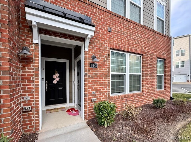 property entrance featuring brick siding