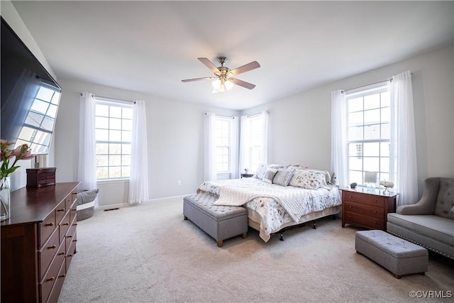 bedroom with baseboards, ceiling fan, visible vents, and light colored carpet