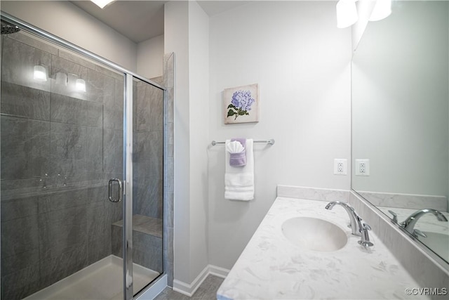 bathroom featuring a shower stall, baseboards, and vanity