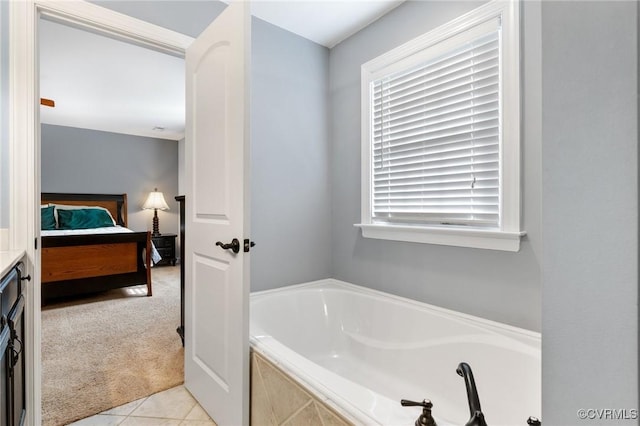 bathroom with tile patterned flooring, a garden tub, vanity, and ensuite bathroom