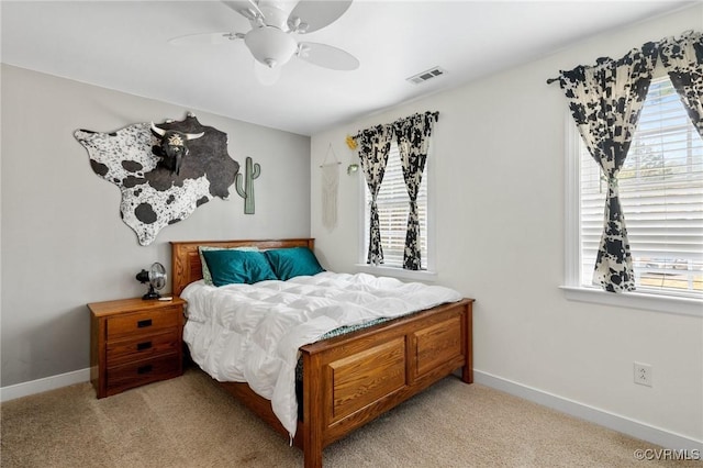 bedroom featuring ceiling fan, visible vents, baseboards, and light carpet