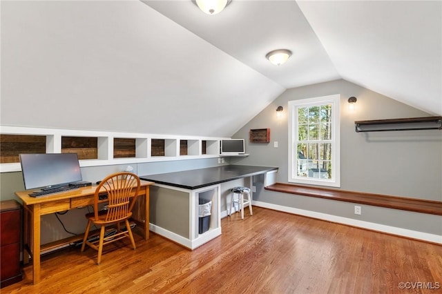 office featuring lofted ceiling, wood finished floors, and baseboards