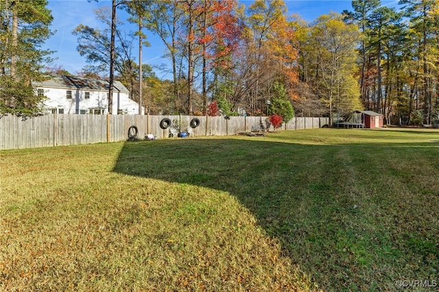 view of yard with an outdoor structure, a storage unit, and a fenced backyard