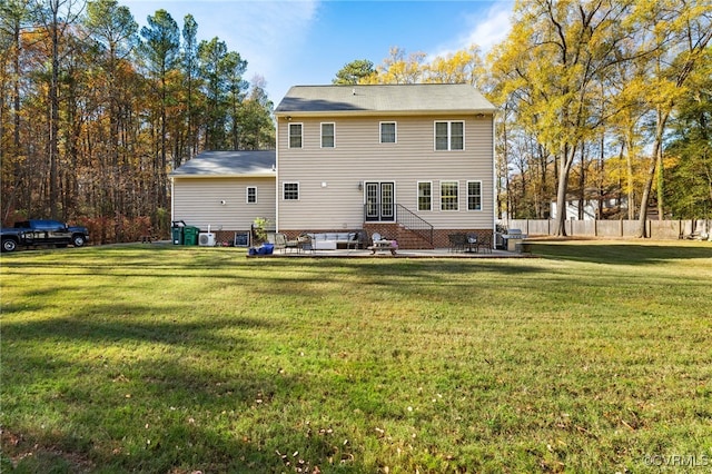 back of property featuring a patio area, a lawn, and fence