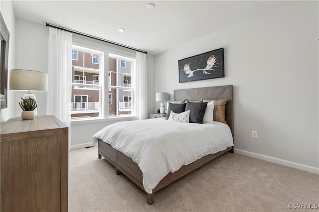 bedroom with baseboards and light colored carpet